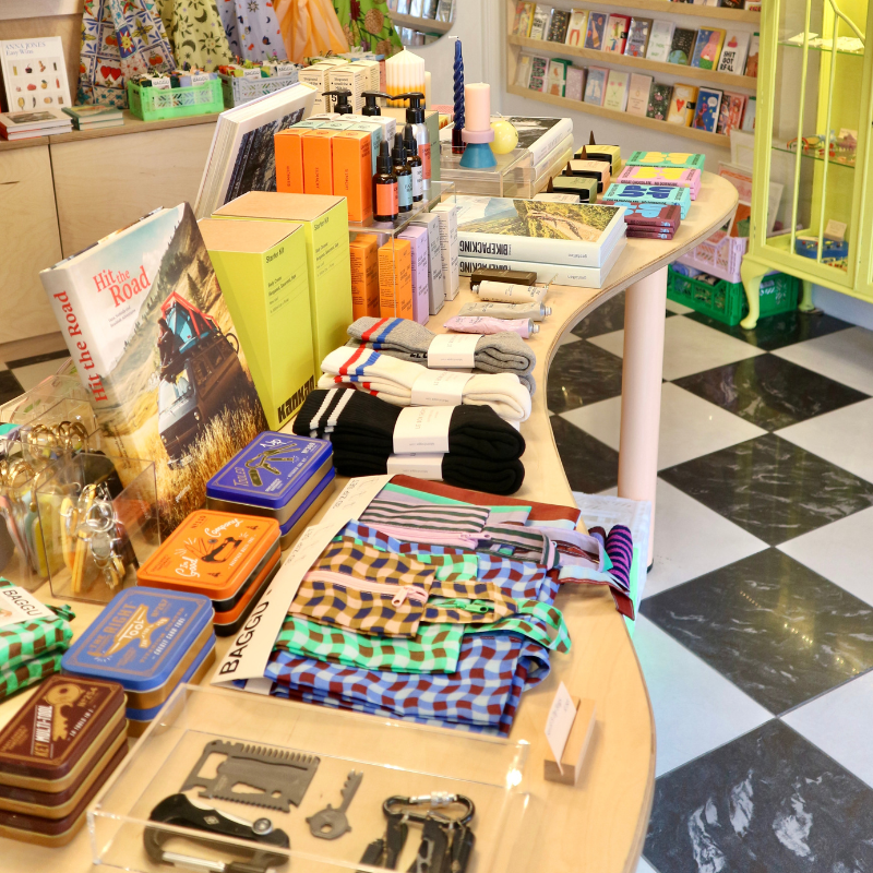 photo of the inside of the shop with a mens gifting table laid out, showcasing multi-tools, socks, books, self care items and more